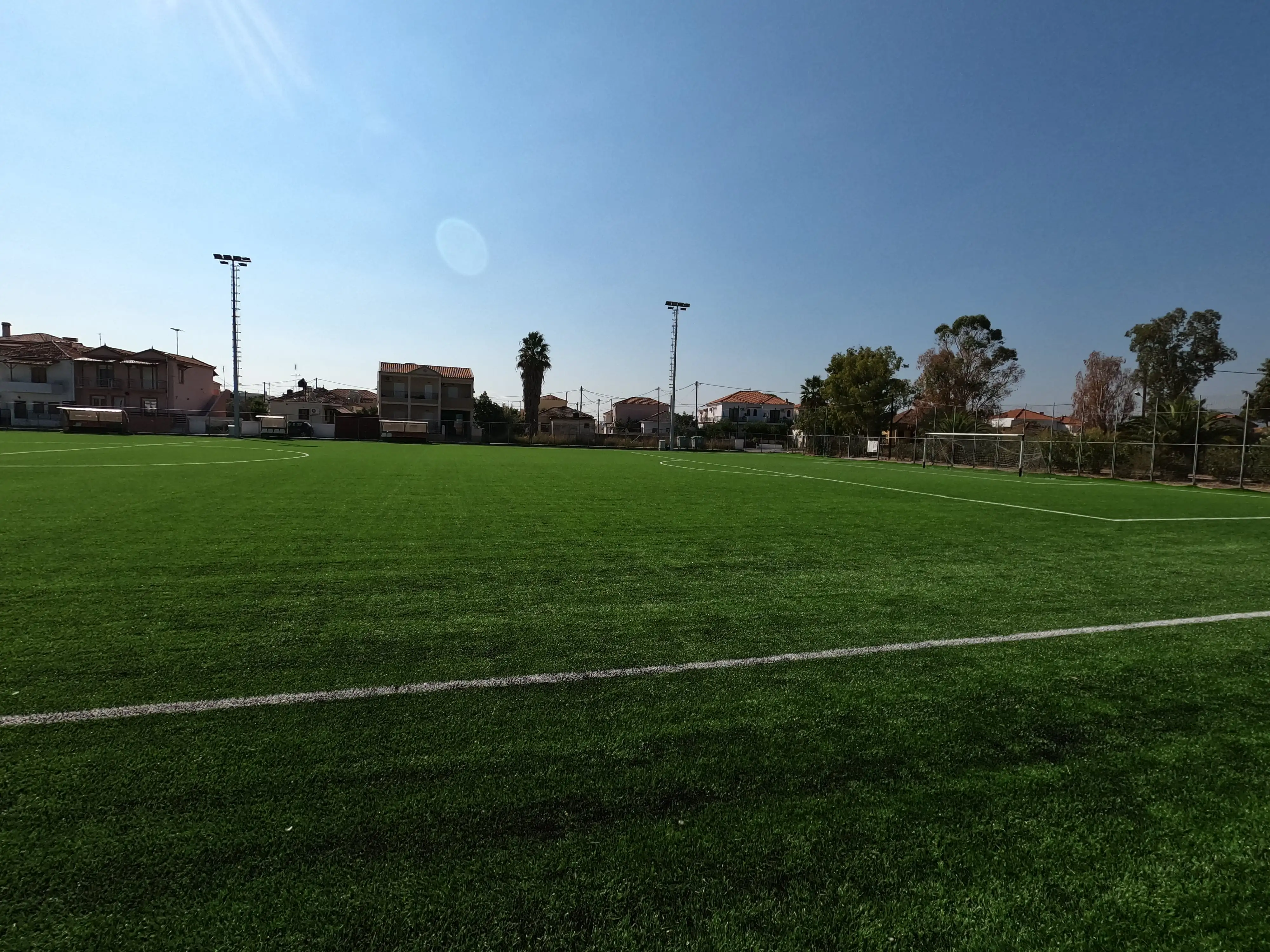 Γήπεδο Καλλονής όπου απεικονίζεται ο τεχνιτός χλωροτάπητας, ένα από τα δύο καινούργια τέρματα και στο βάθος φαίνονται οι δύο καινούργιοι ιστοί φωτισμού του γηπέδου.